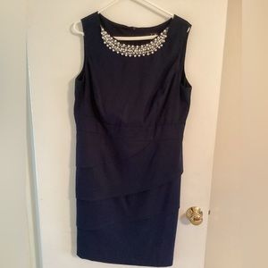 Sleeveless dress with beads at collar.